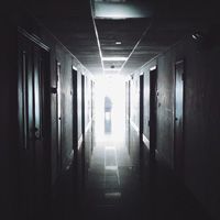 A dimly lit corridor with doors on the side.