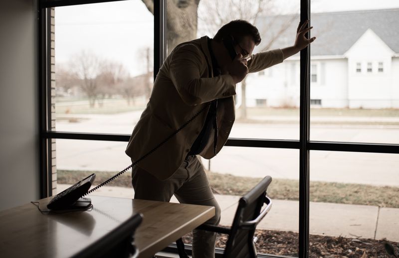 A businessman on the phone in a dimly lit room.