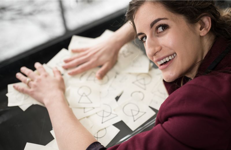 Businesswoman holding post-it notes with the RCE logomark.