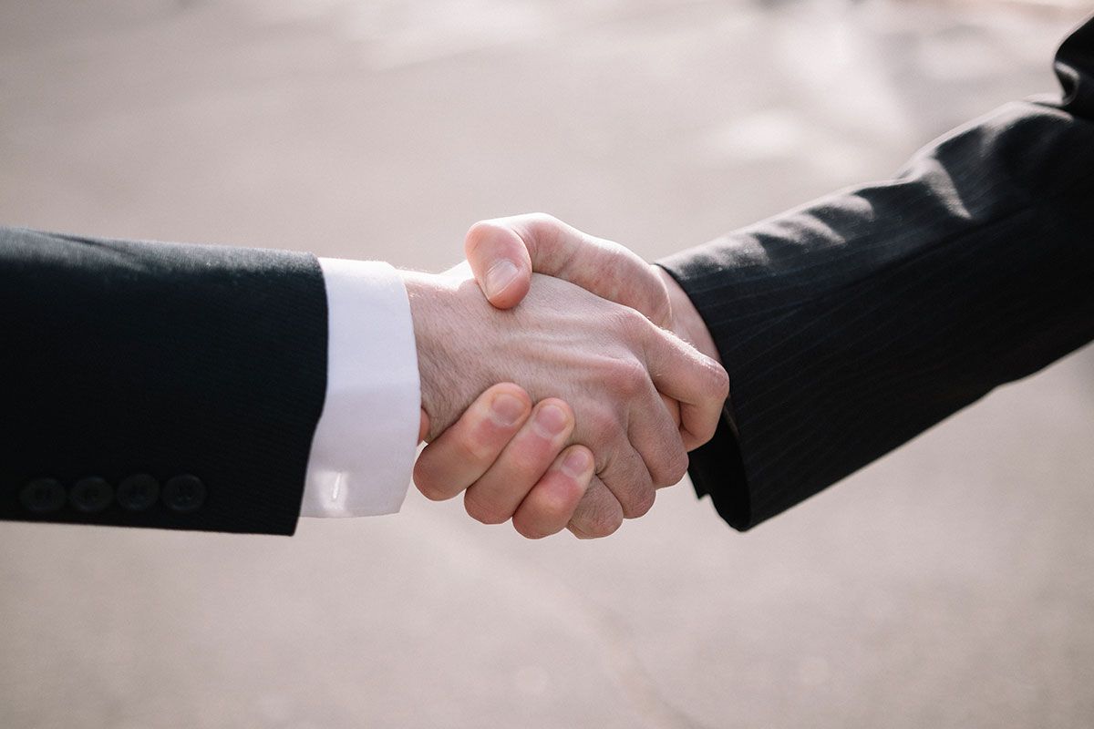 Two business men completing a powerful handshake gesture.