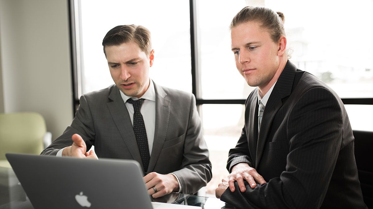 Two businessmen formulating a grand idea, happily.